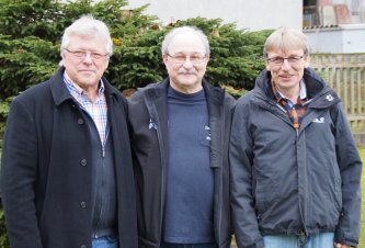 Die beiden Geschäftsführer Franz Haas (links) und Klaus Schrödel (rechts) gratulieren Wolfgang Gruber an seinem Ehrentag zu Hause. 